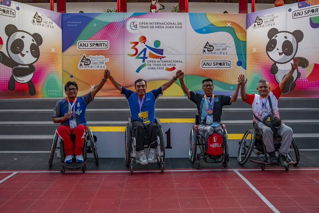 Medallistas de paratenis de mesa levantando los brazos en el podio del Open Juan XXIII